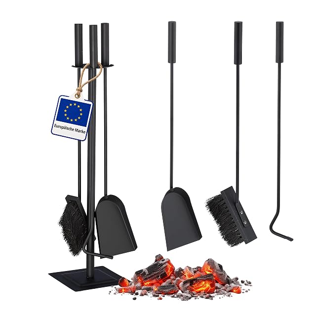 Un juego de herramientas de chimenea negro de cuatro piezas con cepillo, recogedor, atizador y pie para colgarlas